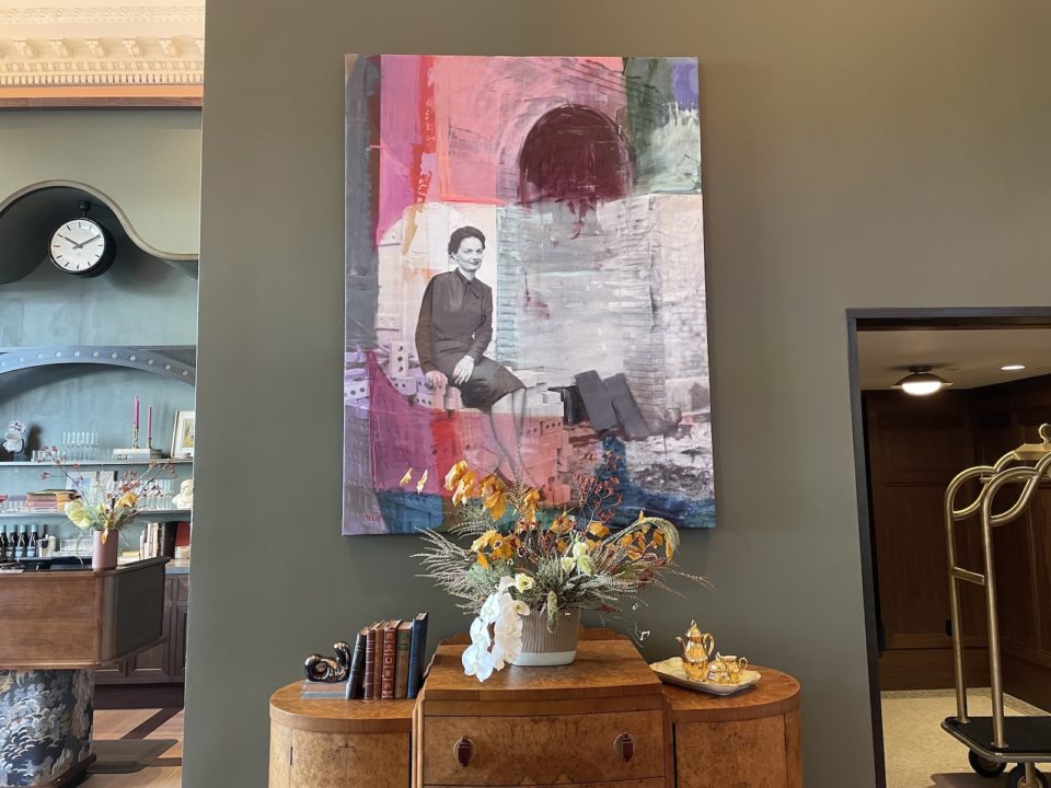 Annie Decamp's mixed-media portrait of Dana Crawford installed above a credenza in the Crawford Hotel's new lobby at Denver Union Station