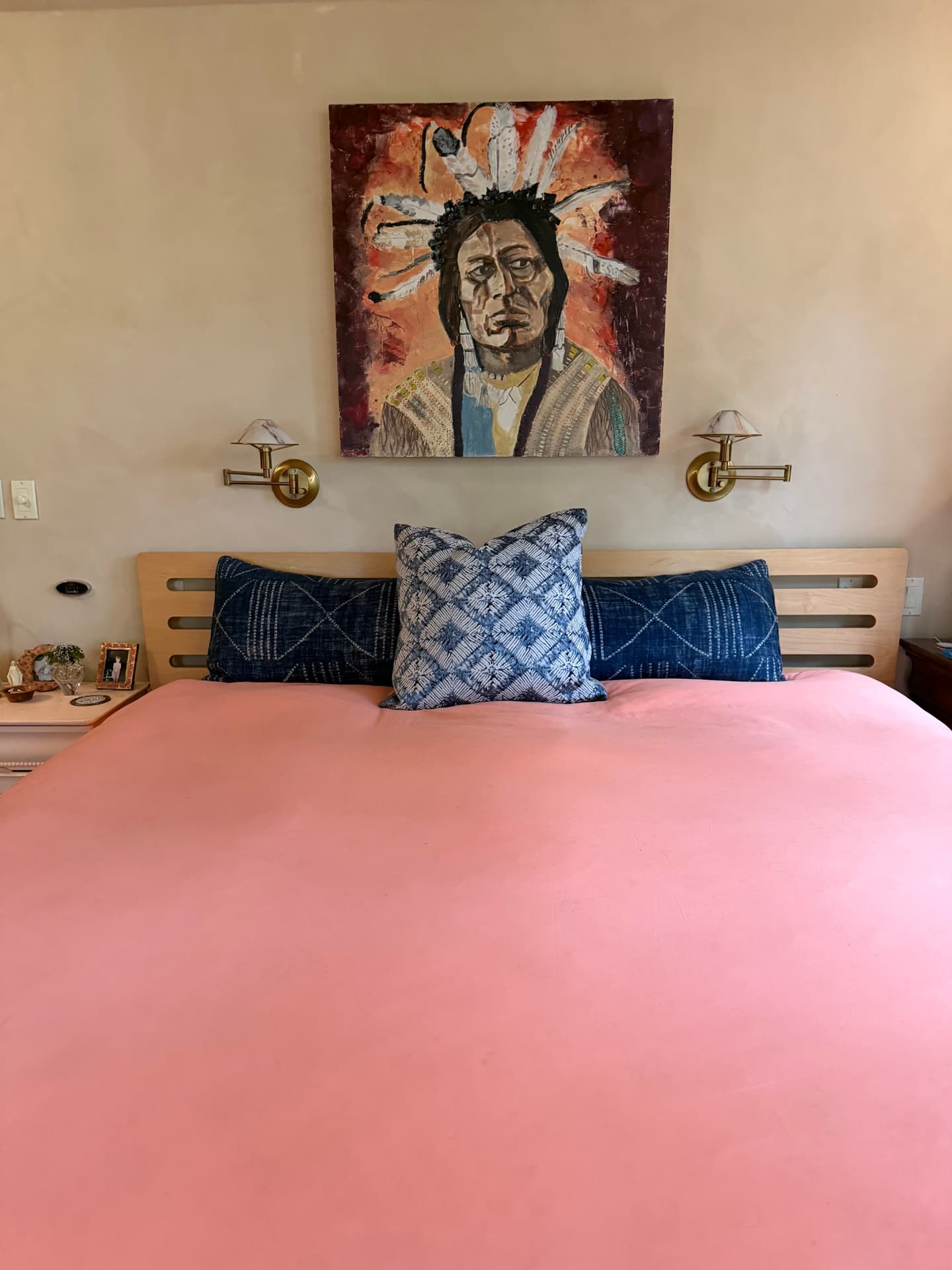 Annie Decamp portrait painting displayed above a bed with a pink coverlet