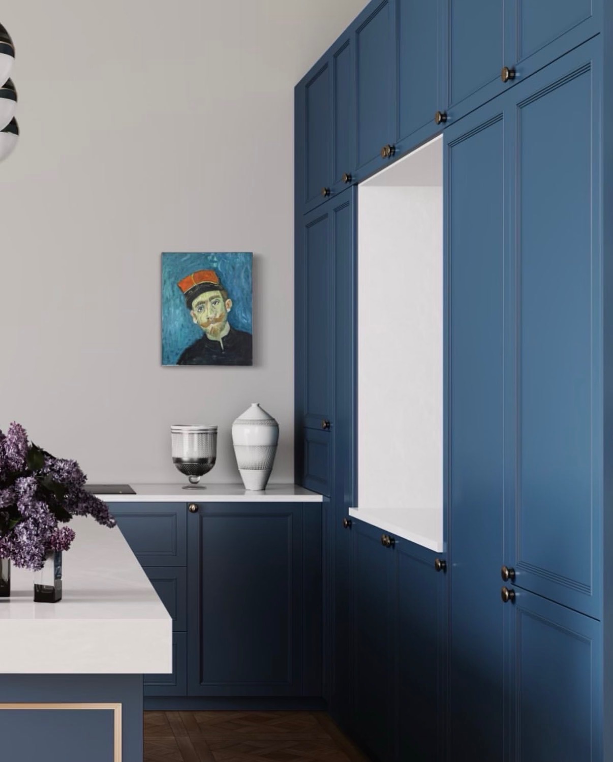 Annie Decamp portrait of a man in a red cap on a light gray wall in a modern blue kitchen