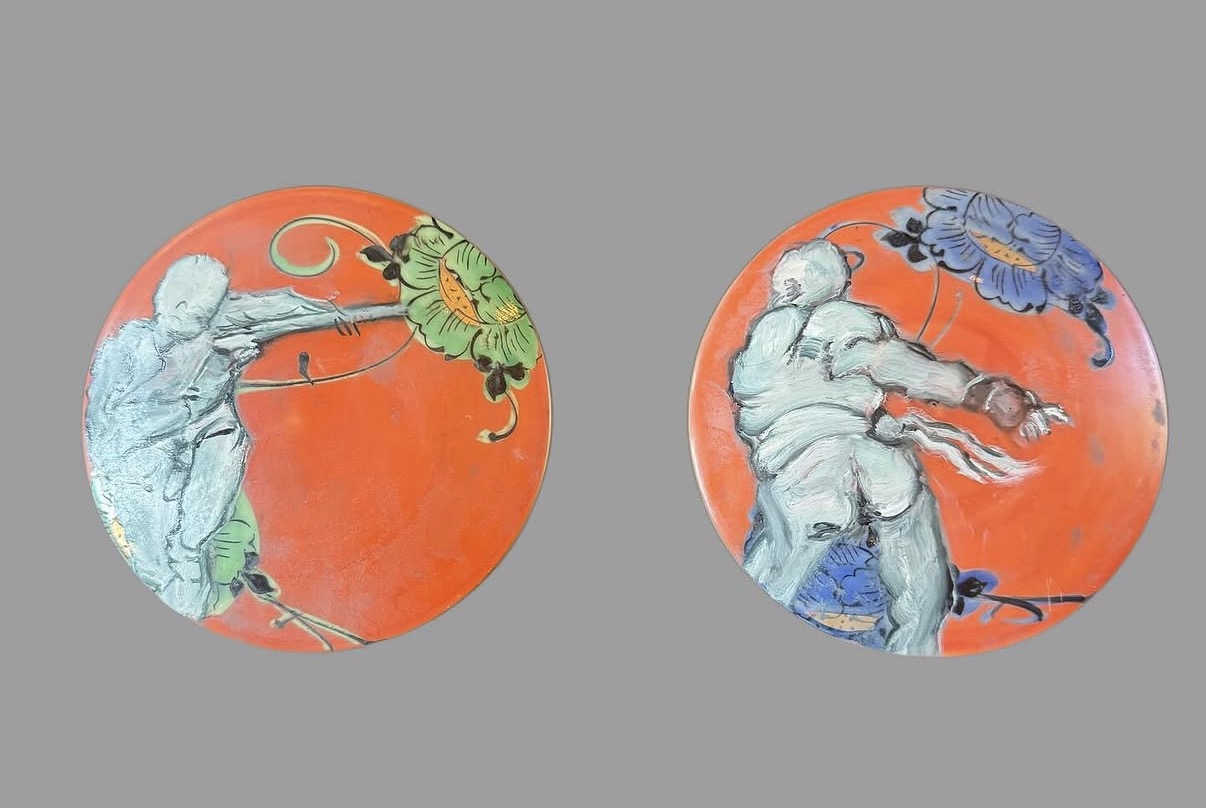 Figures on orange plates (pair), mixed media by Annie Decamp